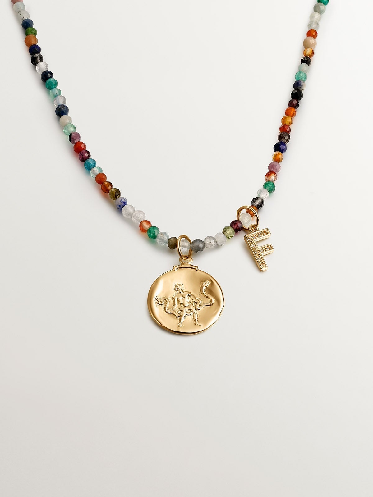 F initial charm made of 925 silver, bathed in 18K yellow gold with white topazes.