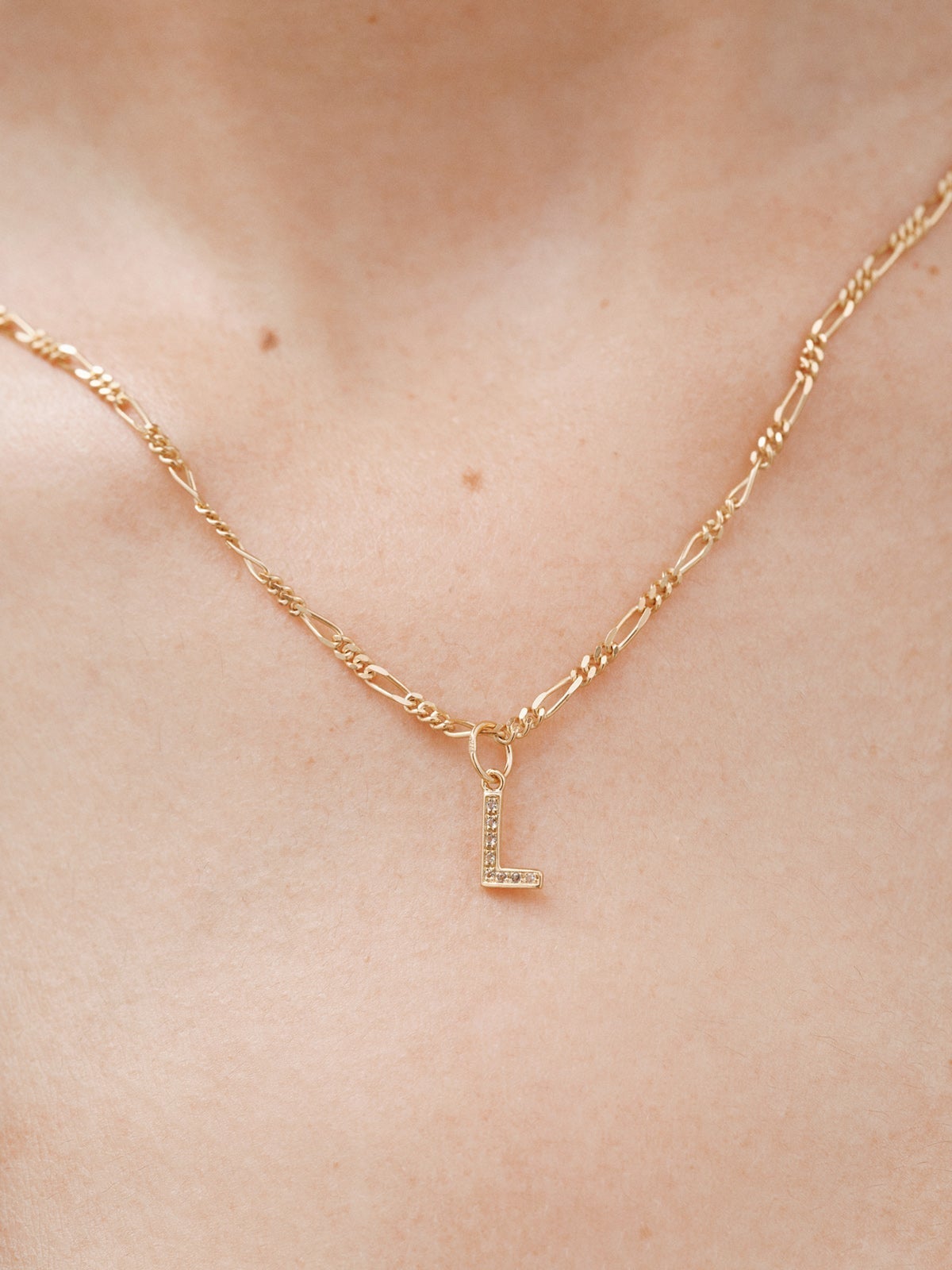 925 Sterling silver charm bathed in 18K yellow gold and white topaz with the initial L.