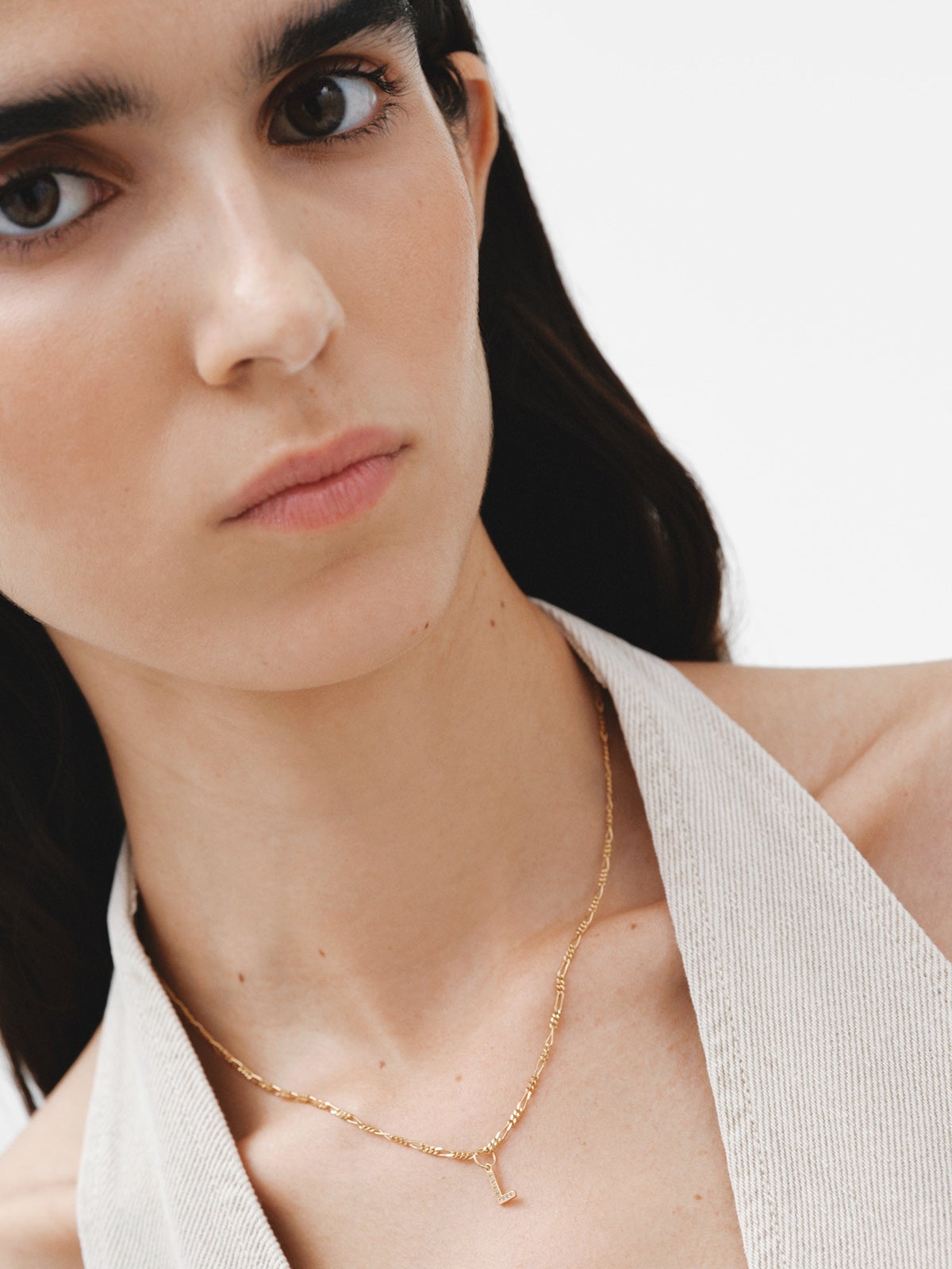 925 Sterling silver charm bathed in 18K yellow gold and white topaz with the initial L.