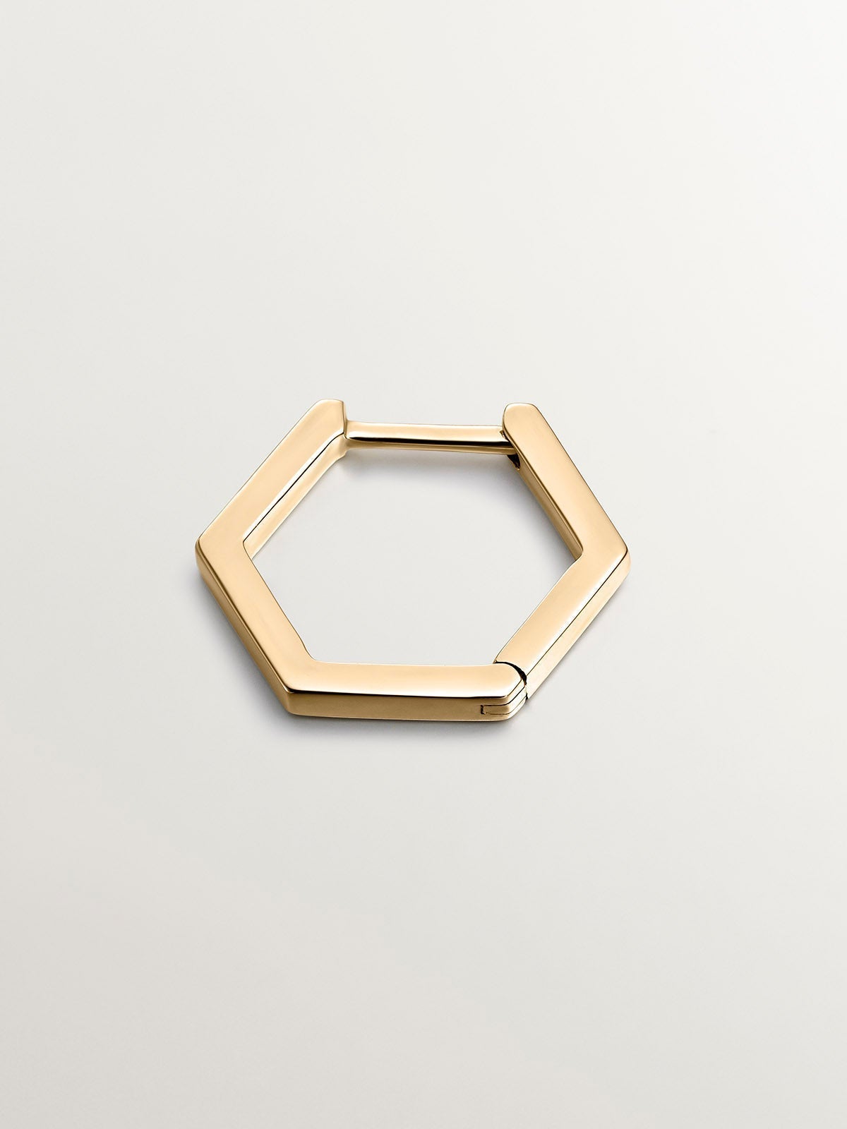 Individual 9K yellow gold hoop earring with hexagonal shape.