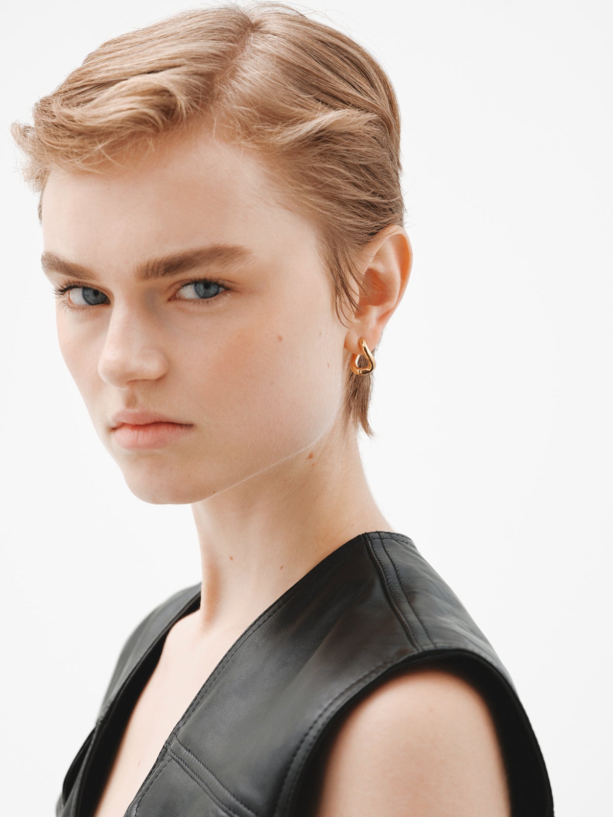 Medium thick 925 silver hoop earrings bathed in 18K yellow gold with a wavy shape.