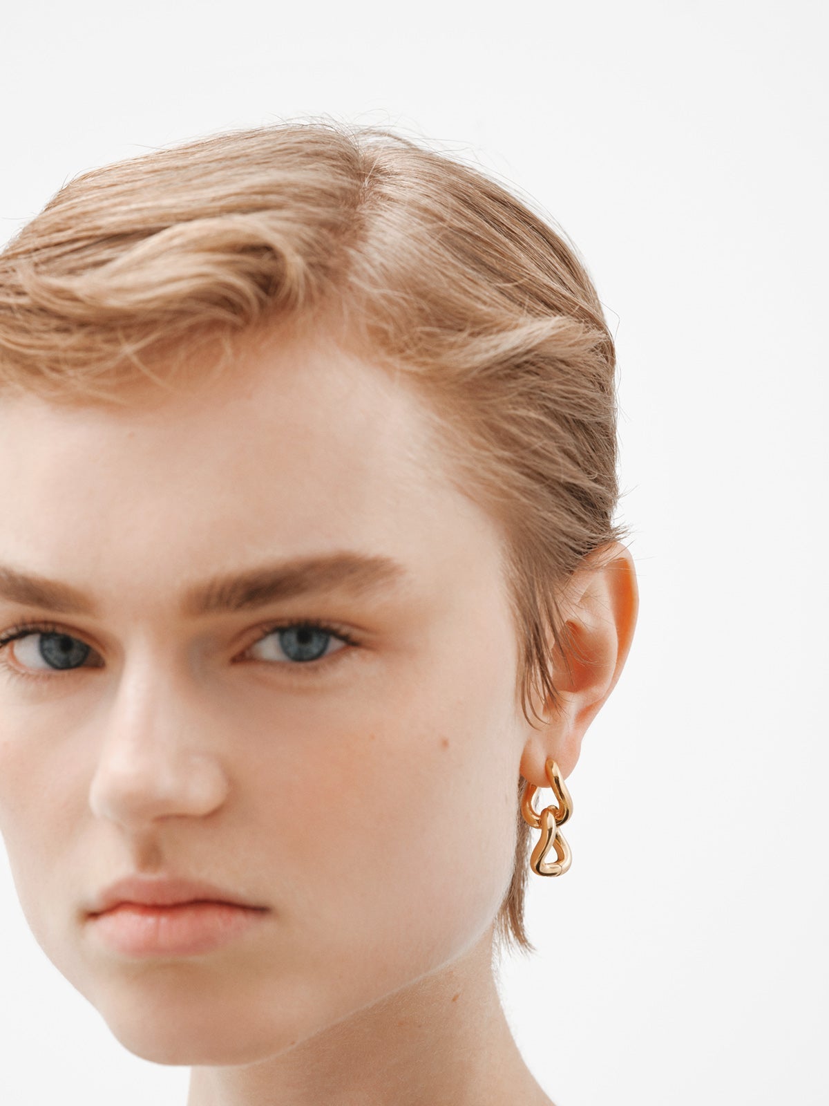 Medium thick 925 silver hoop earrings bathed in 18K yellow gold with a wavy shape.