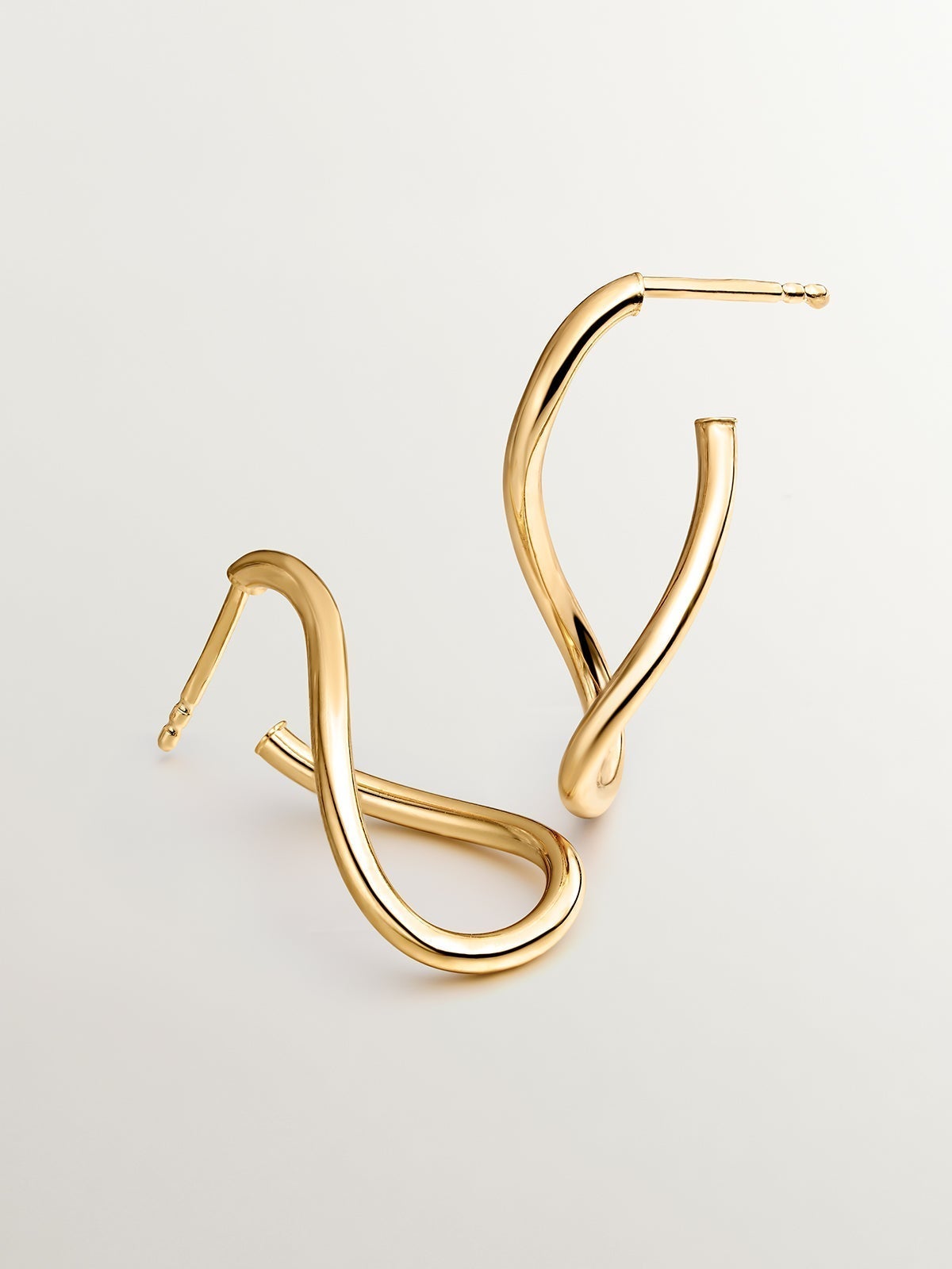 Medium wavy hoop earrings made from 925 silver, plated in 18K yellow gold
