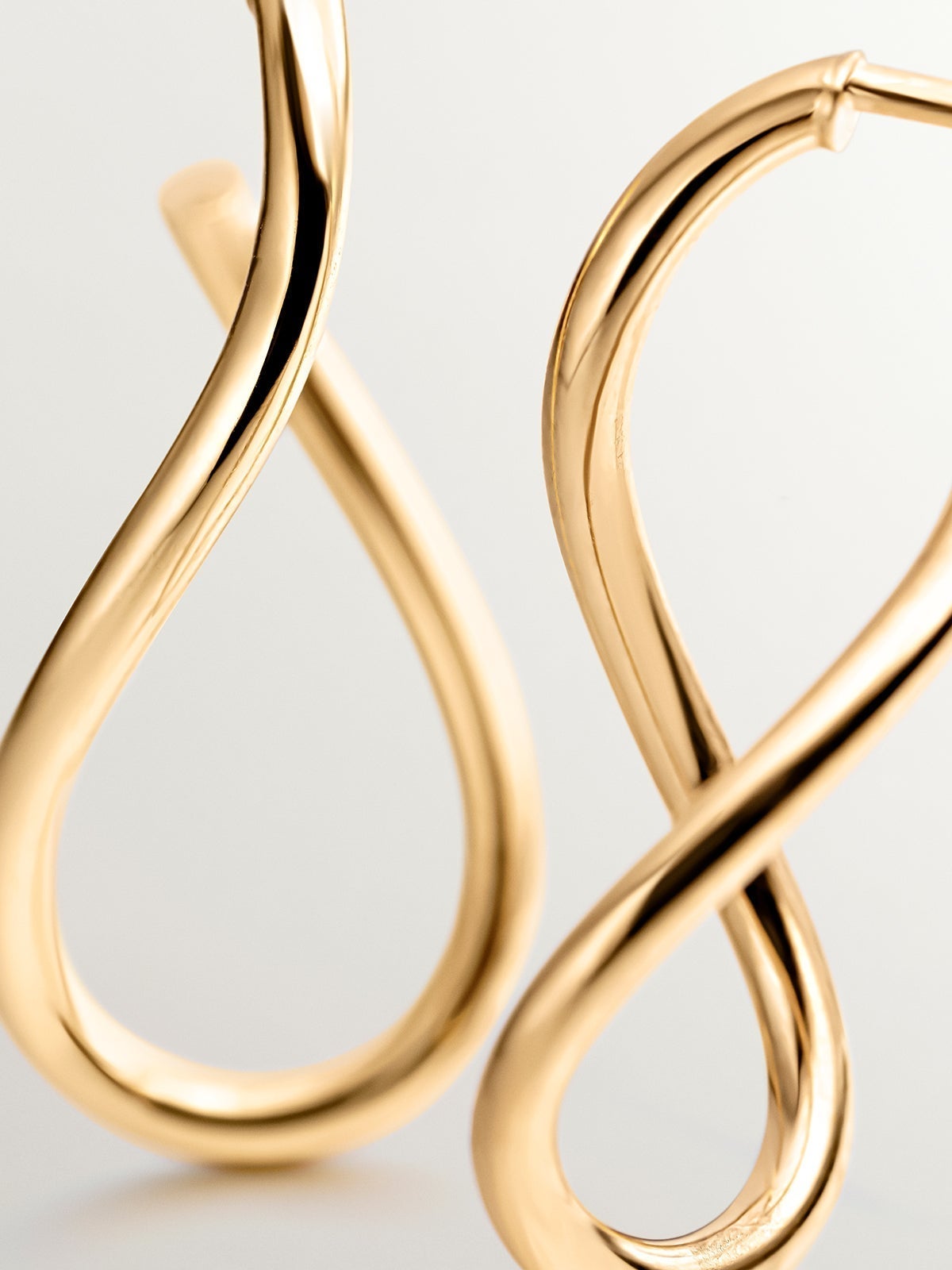 Medium wavy hoop earrings made from 925 silver, plated in 18K yellow gold