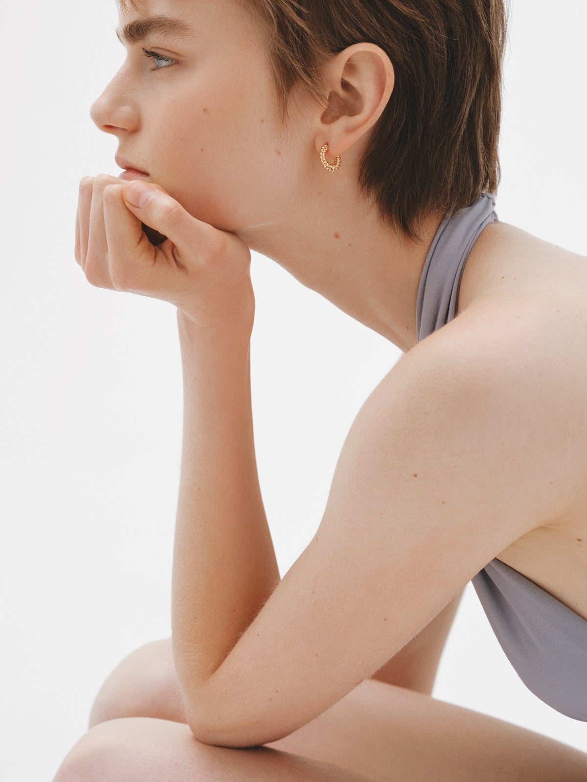 Small hoop earrings made of 925 silver plated in 18K yellow gold with an embossed finish.