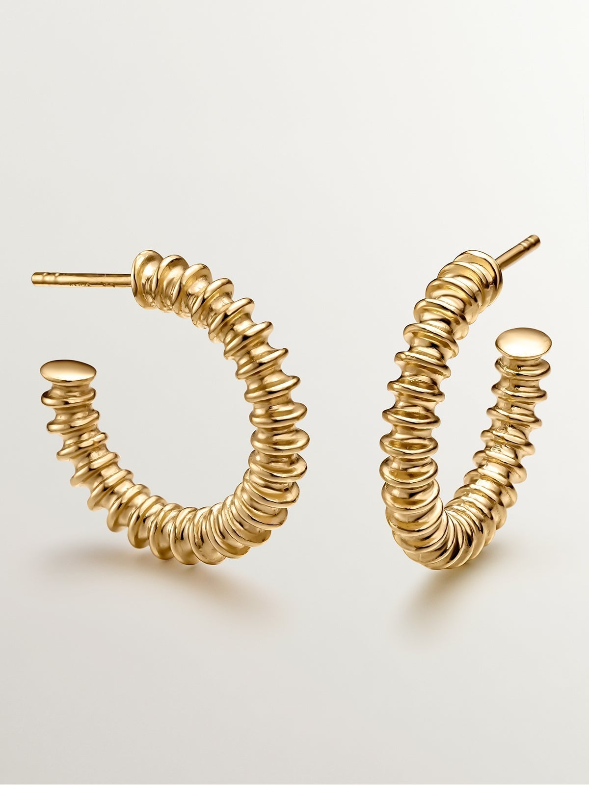 Medium hoop earrings made of 925 silver, coated in 18K yellow gold with a textured finish.