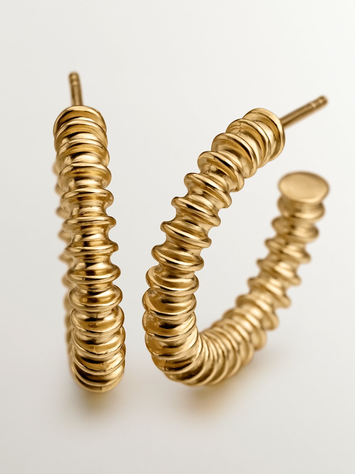 Medium hoop earrings made of 925 silver, coated in 18K yellow gold with a textured finish.