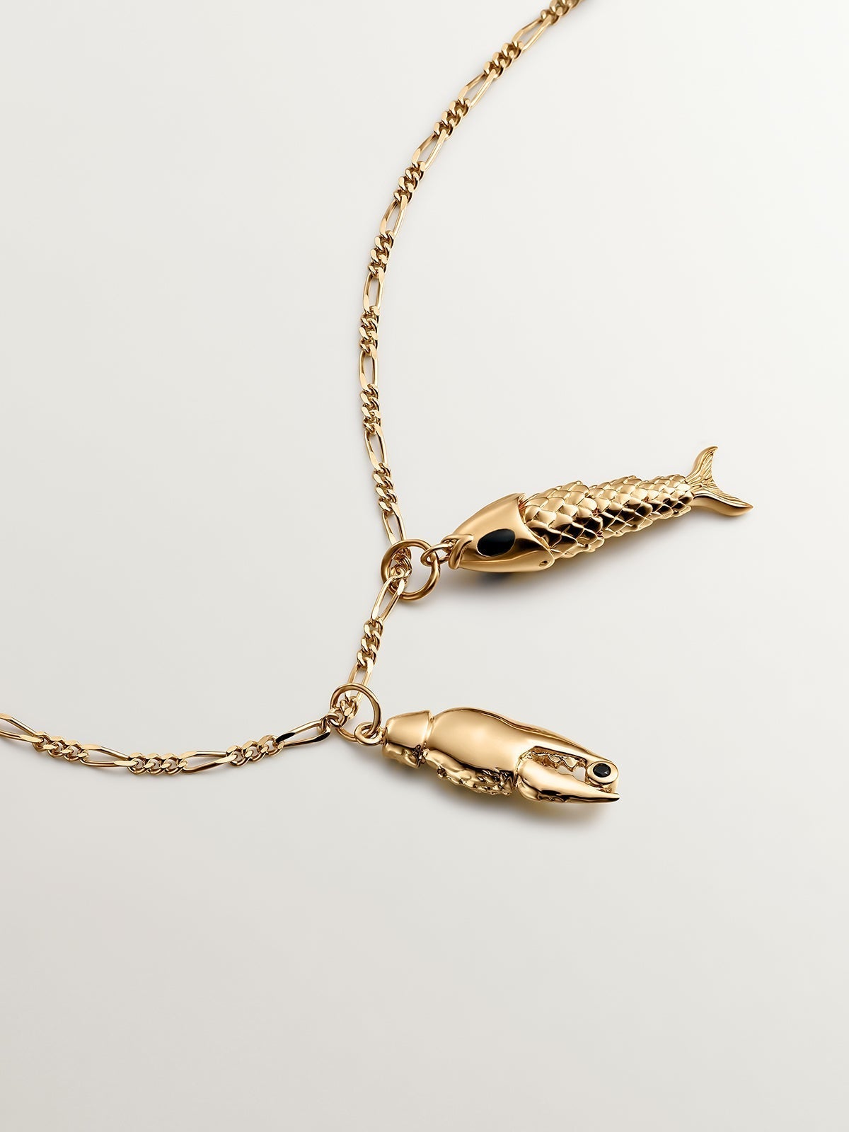 925 Silver charm bathed in 18K yellow gold with black enamel and fish shape.