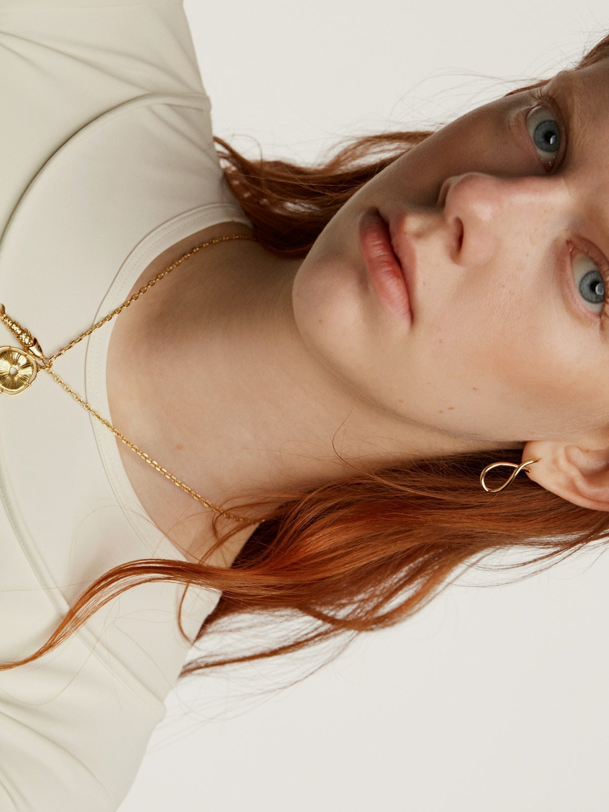 925 Silver charm, gold-plated in 18K yellow gold, with an irregular medallion shape and white topaz stones.