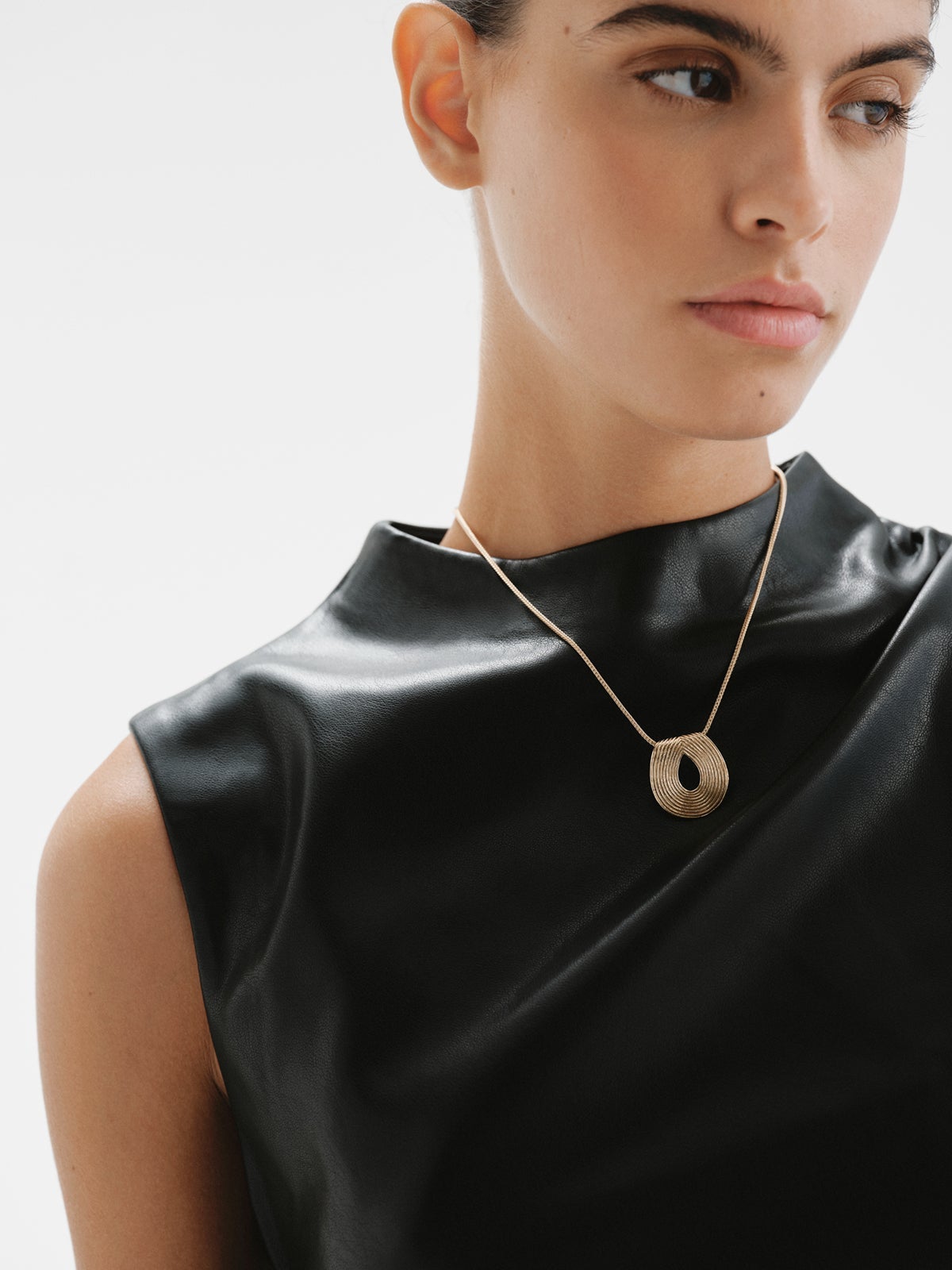Oval pendant made of 925 silver bathed in 18K yellow gold with relief.