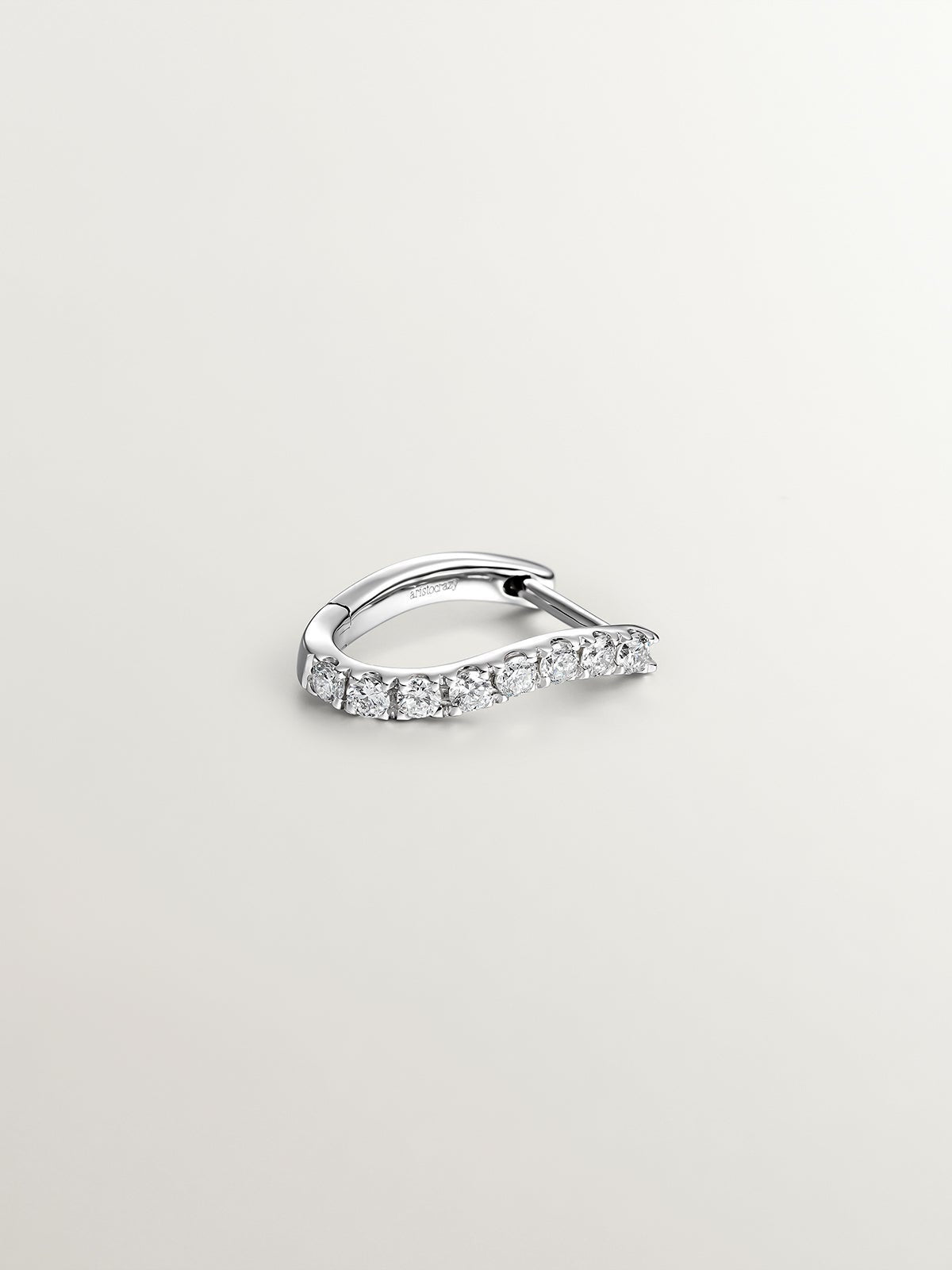 Individual earring of small 18K white gold hoop with diamonds in a wavy shape.
