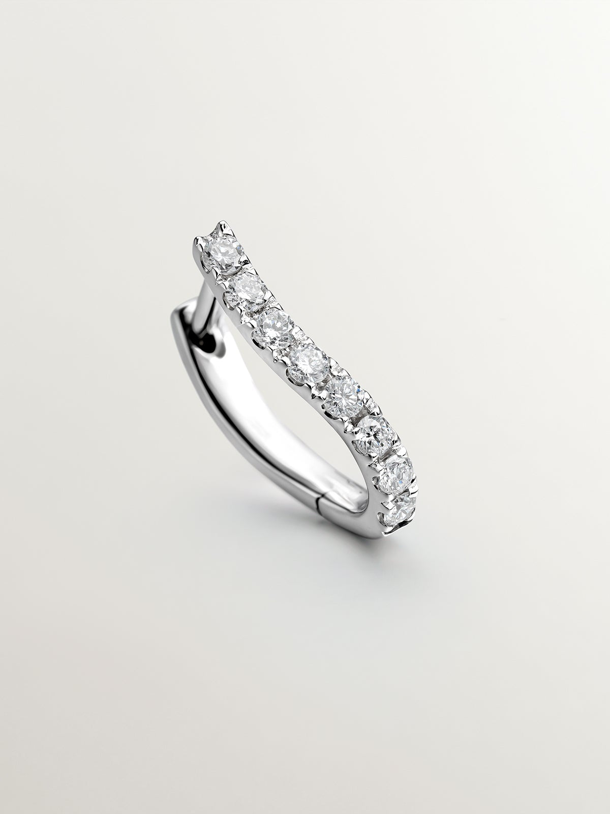 Individual earring of small 18K white gold hoop with diamonds in a wavy shape.