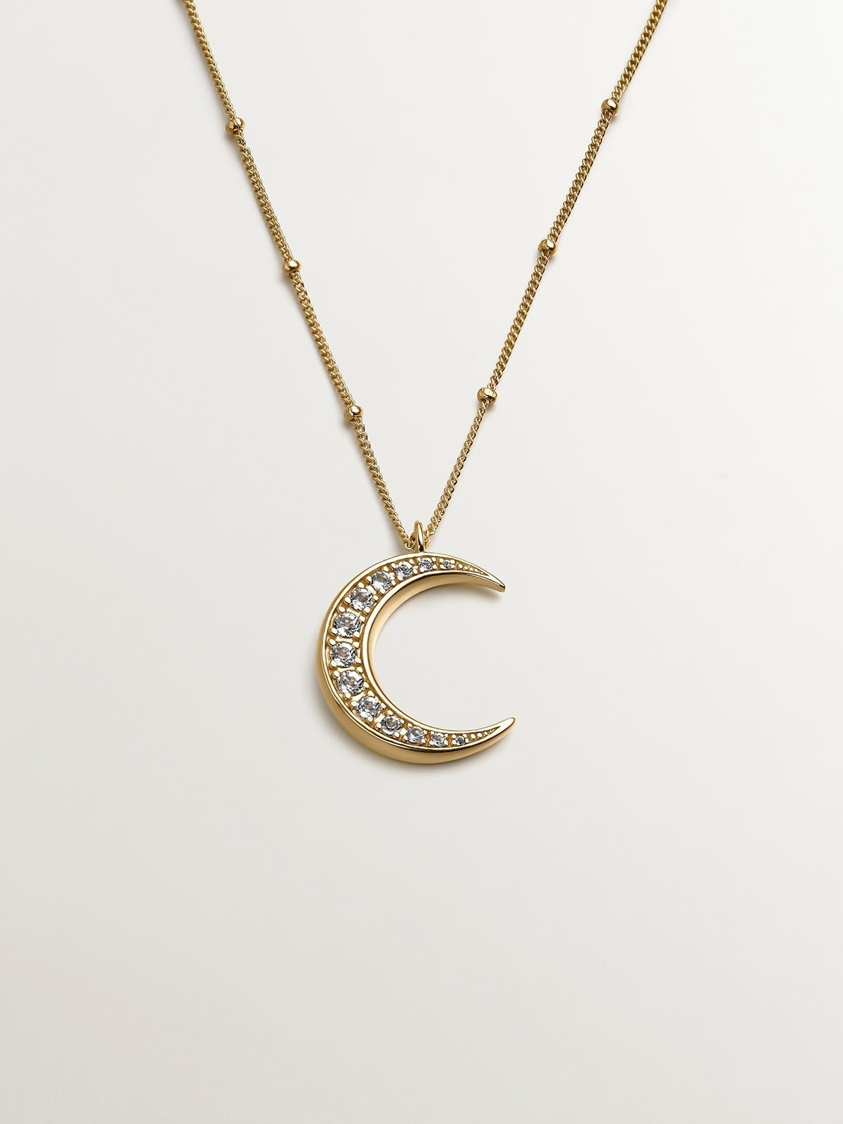 925 Silver pendant bathed in 18K yellow gold with a moon and white topazes.