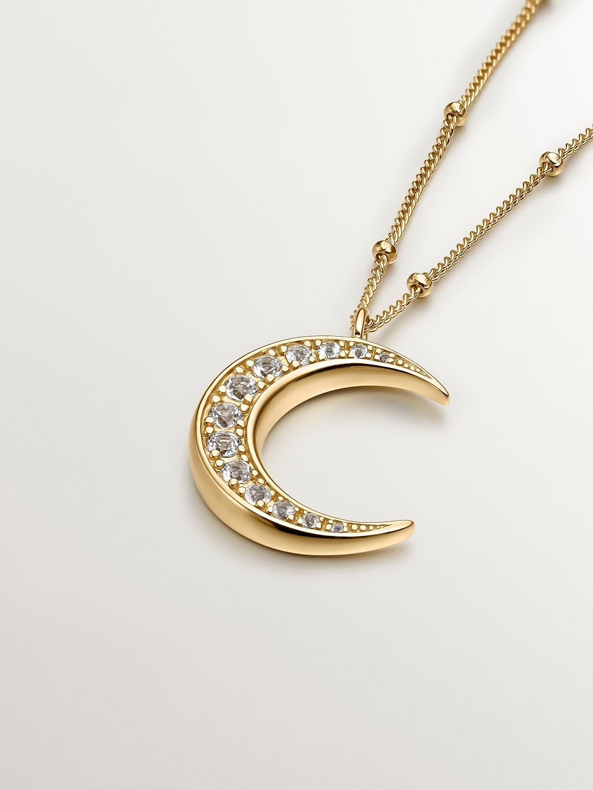 925 Silver pendant bathed in 18K yellow gold with a moon and white topazes.