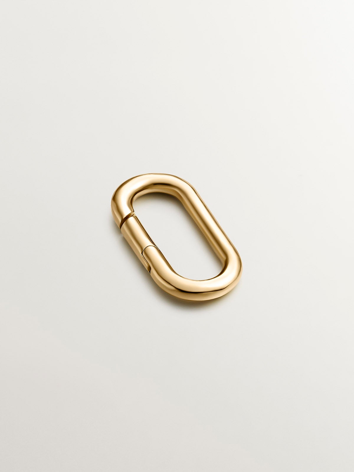 Oval carabiner in 925 silver coated in 18K yellow gold.