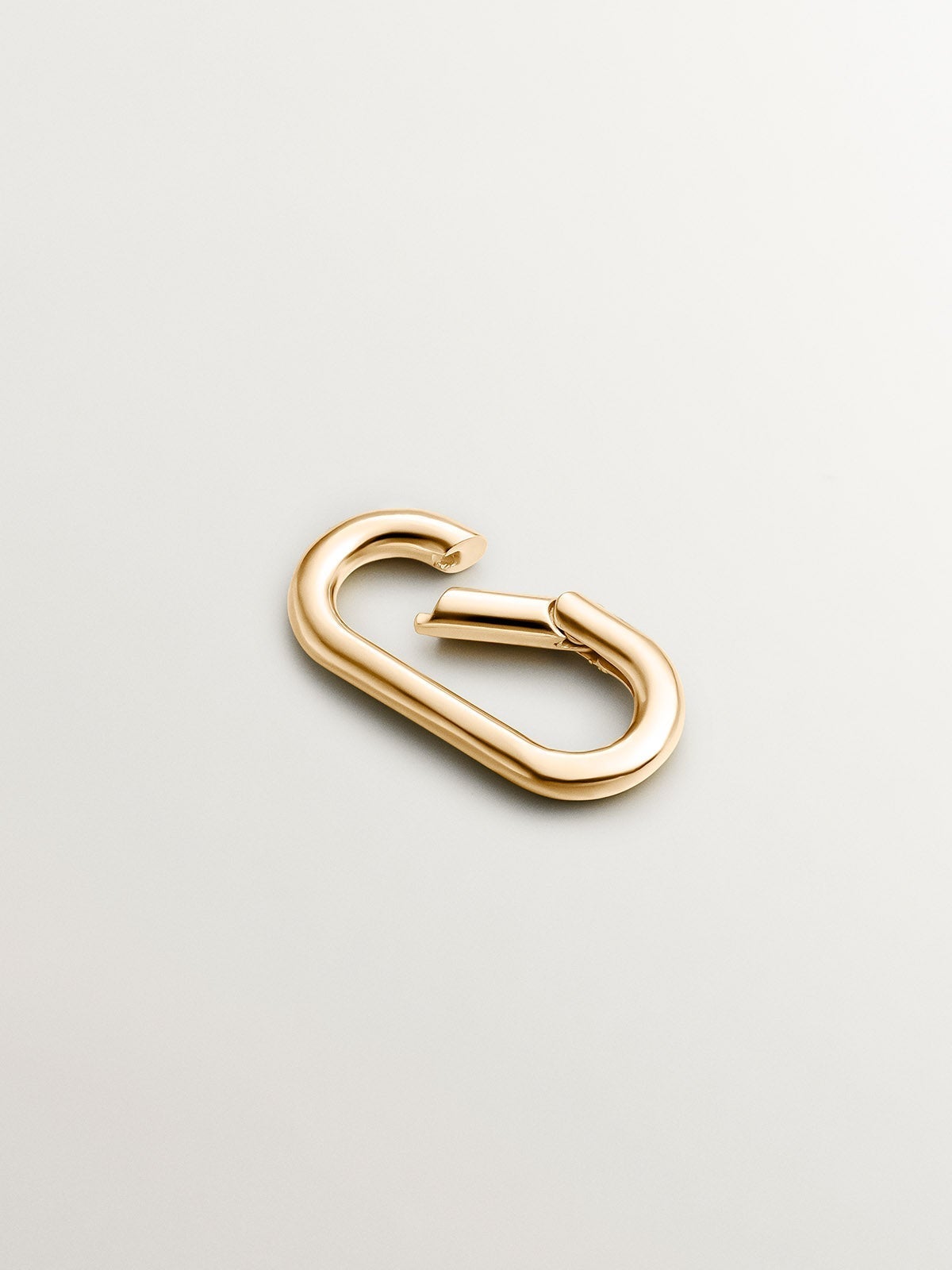 Oval carabiner in 925 silver coated in 18K yellow gold.