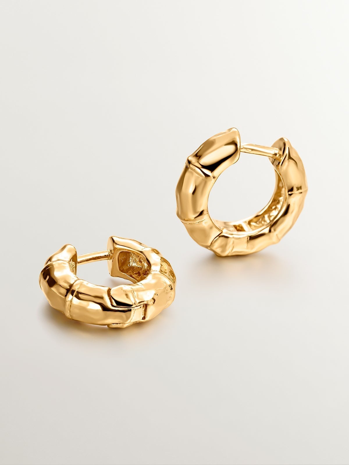 Small hoop earrings made of 925 silver, bathed in 18K yellow gold with a bamboo texture.