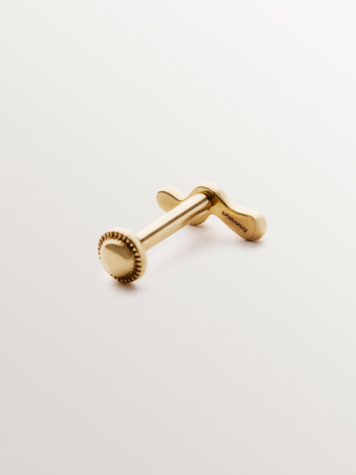 Individual 18K yellow gold piercing with an organic wave shape