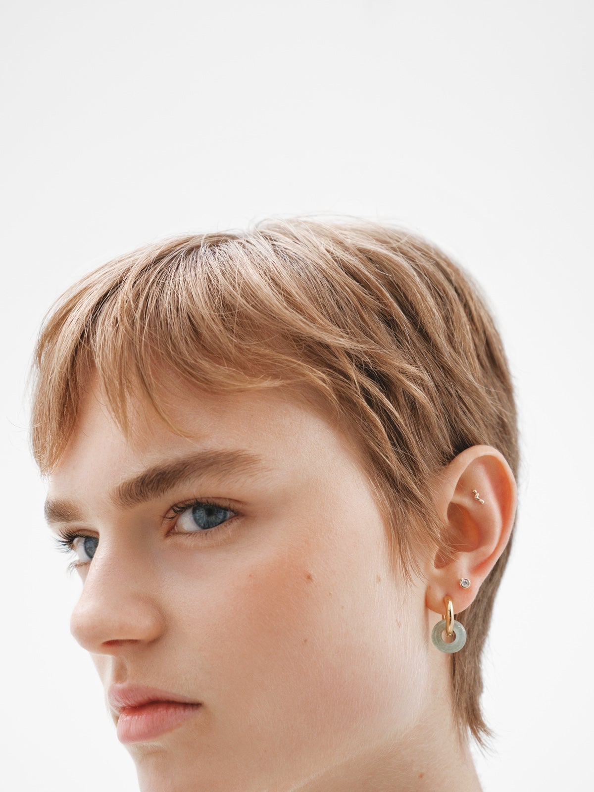 Individual 18K yellow gold piercing with an organic wave shape