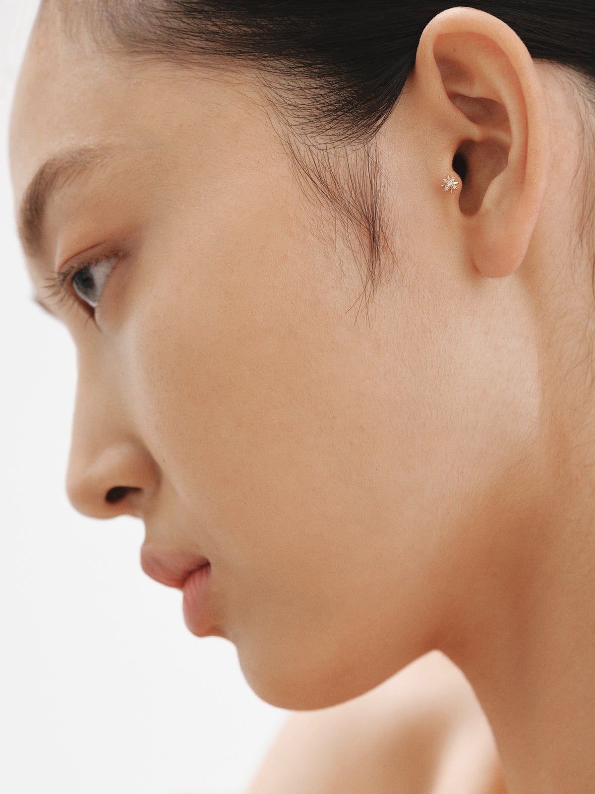 Individual piercing in 18K yellow gold with white diamonds