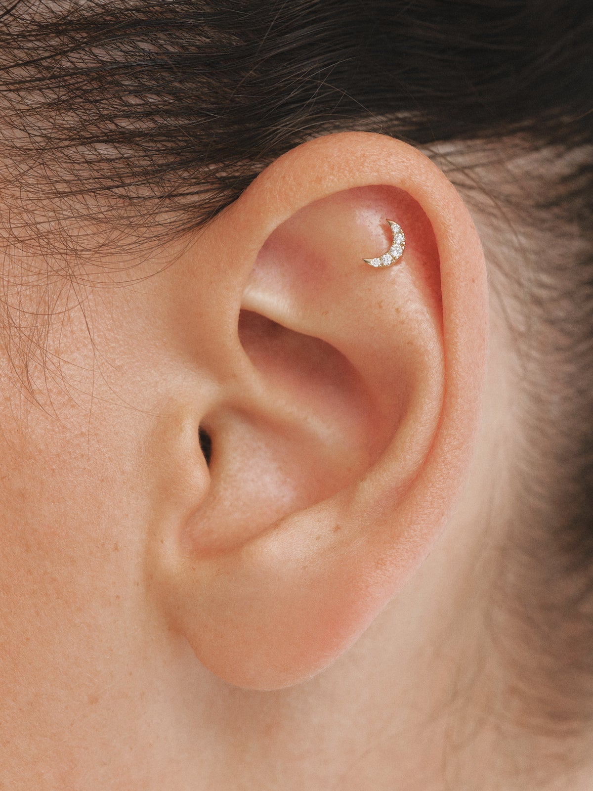 18K yellow gold piercing with brilliant cut diamonds and a moon shape