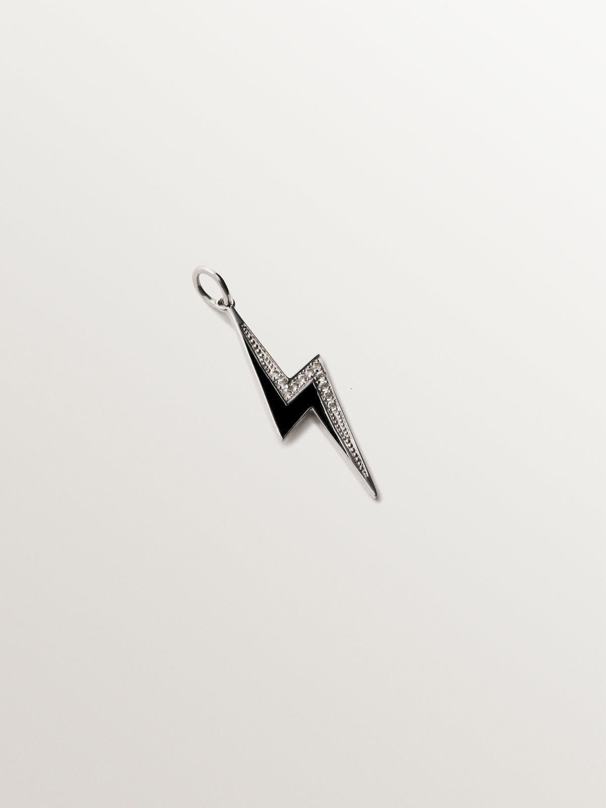 925 silver charm with white topaz and black enamel detail in the shape of a lightning bolt