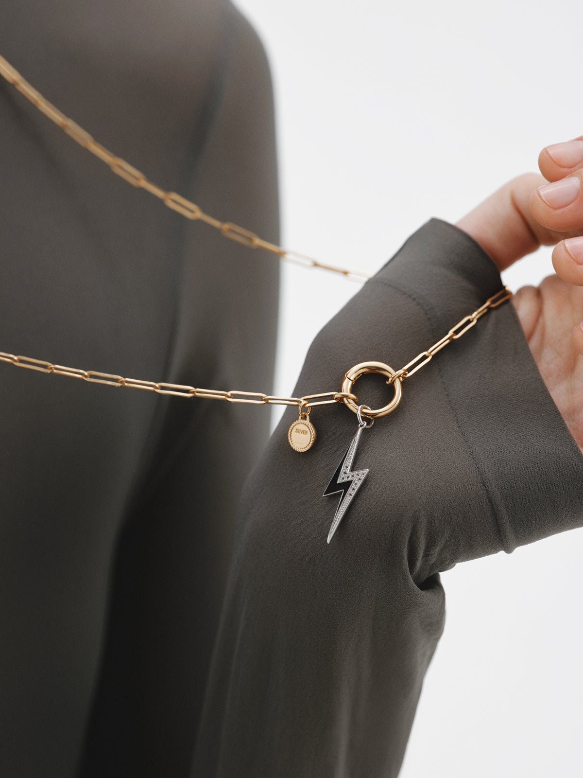 925 silver charm with white topaz and black enamel detail in the shape of a lightning bolt
