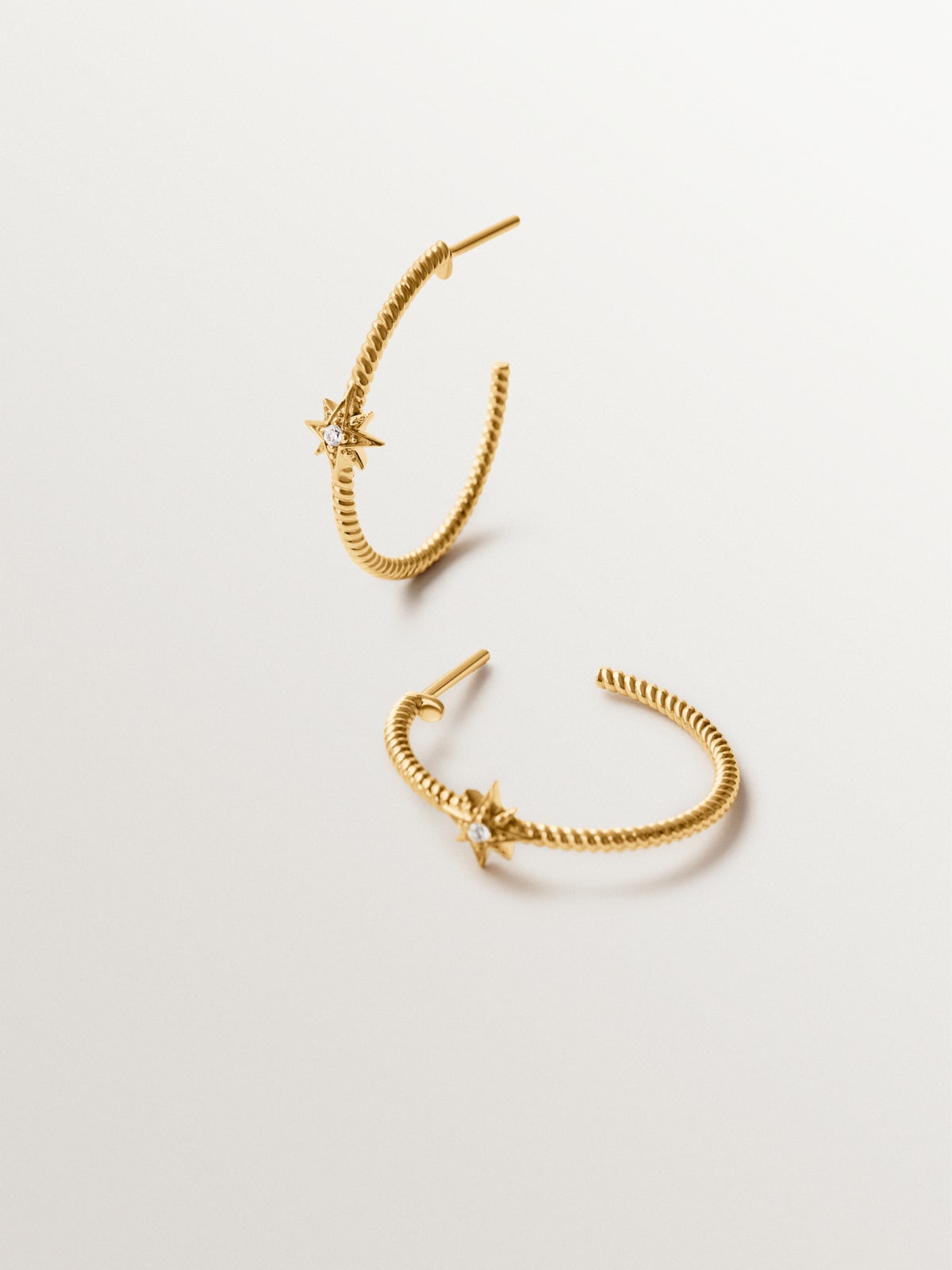 Hoop earrings with galloned texture in 925 silver plated in 18K gold with white topaz and stars