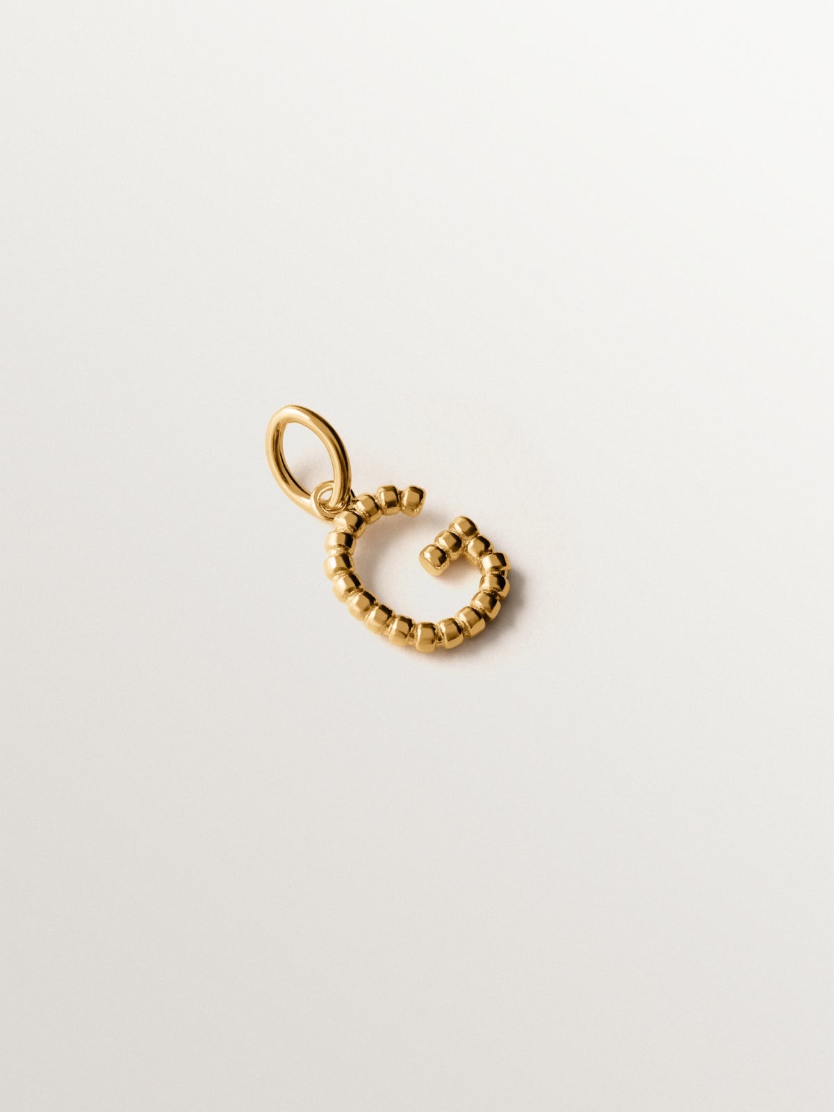 925 silver charm plated in 18K yellow gold with letter G and dial motifs