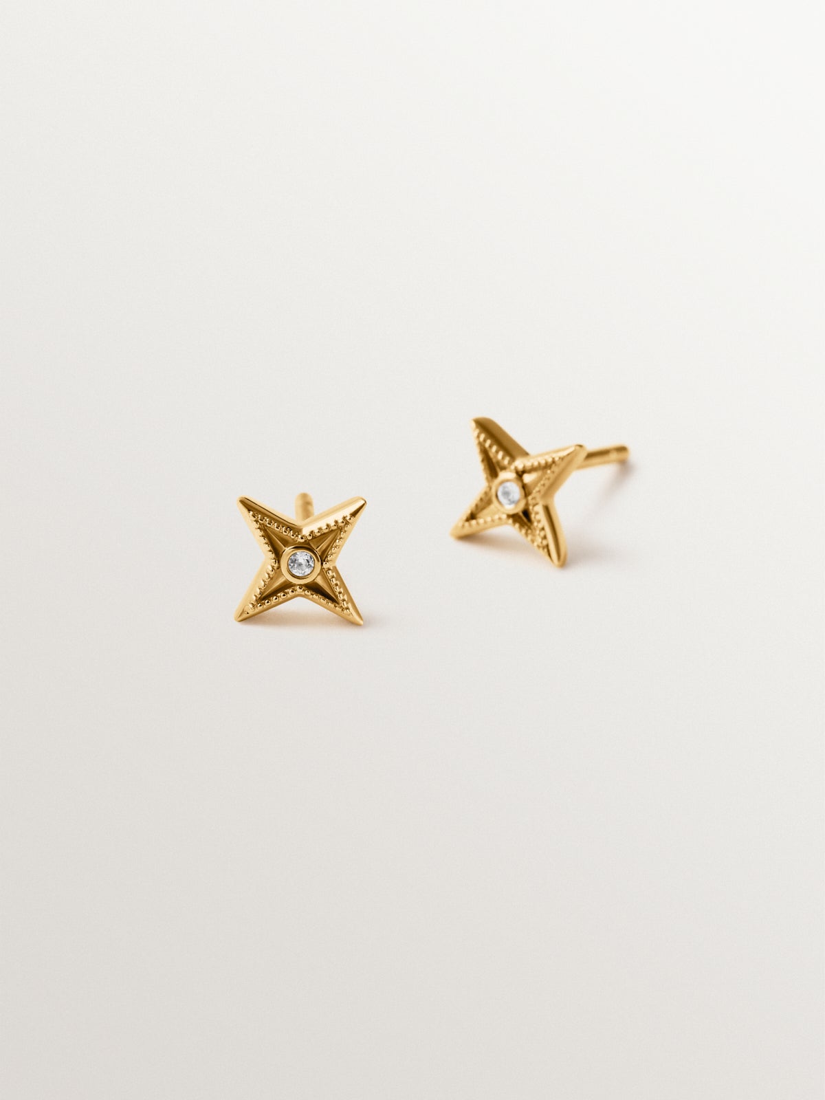 925 silver earrings plated in 18K yellow gold shaped like stars with white topaz