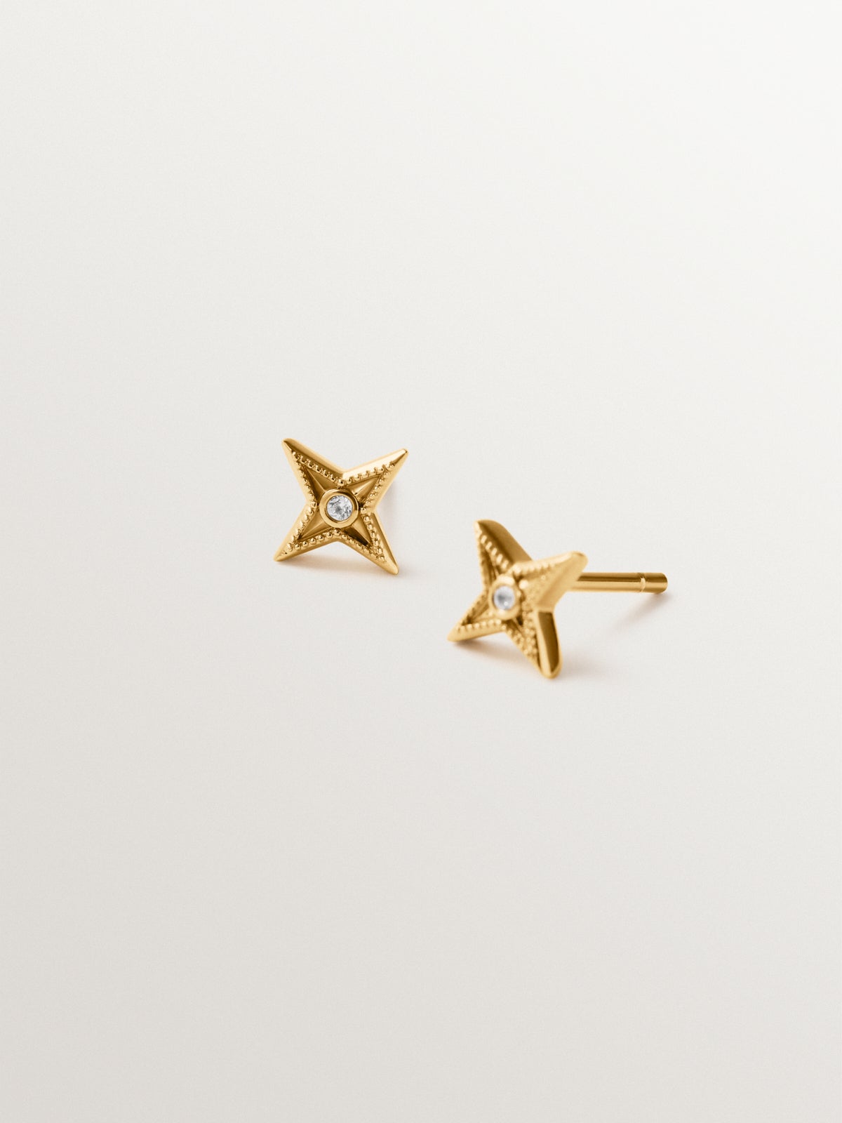 925 silver earrings plated in 18K yellow gold shaped like stars with white topaz