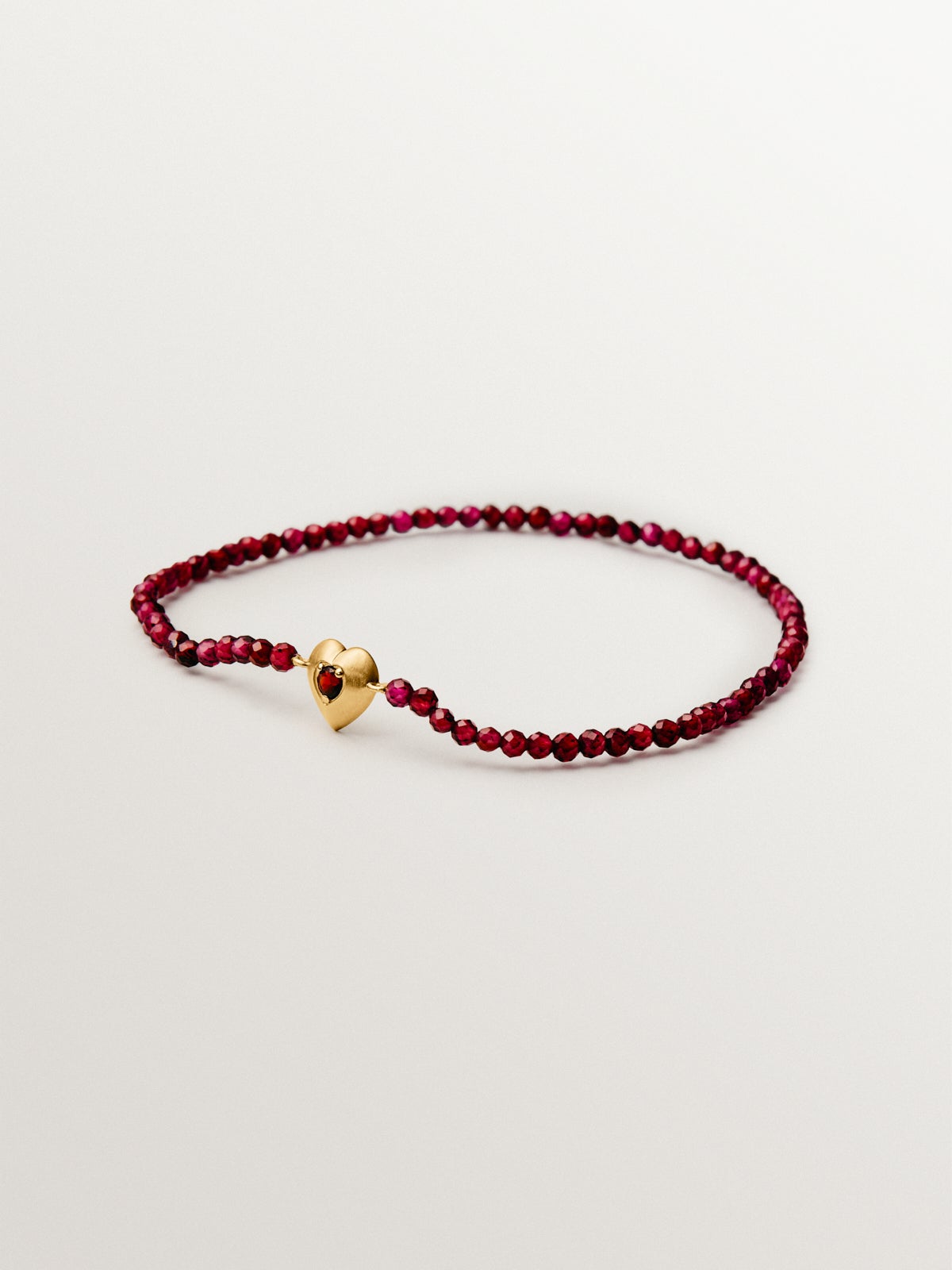 18K yellow gold plated silver bracelet with garnet beads and heart shape