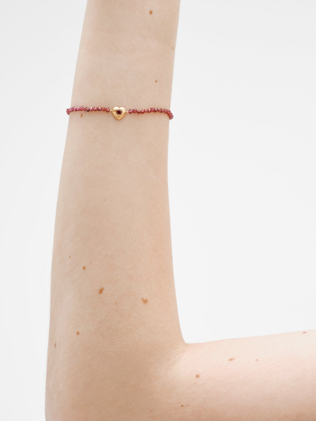 18K yellow gold plated silver bracelet with garnet beads and heart shape