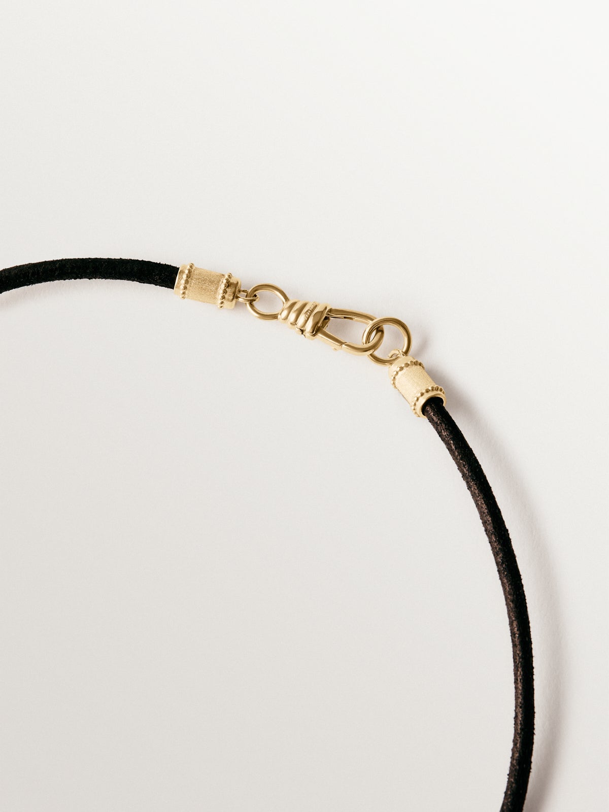 Plain black leather cord with 925 silver finishes plated in 18K yellow gold