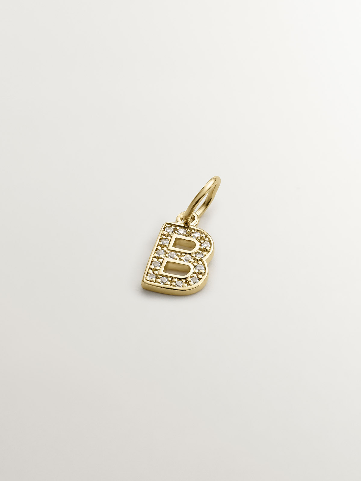 Initial B charm, made of 925 silver coated in 18K yellow gold and adorned with white topaz.